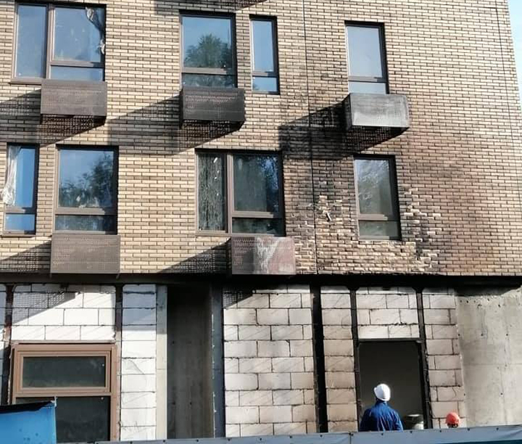 На востоке Москвы рабочие пытались отмыть фасад реновационного дома от копоти после пожара